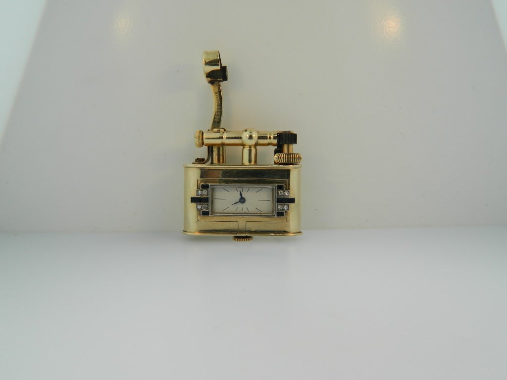 An extremely rare, and possibly unique yellow gold, platinum, and onyx Bijou lighter with watch by Dunhill. This is the only Dunhill Bijou model lighter we have ever known to be produced with a watch! Totally original and in working order.