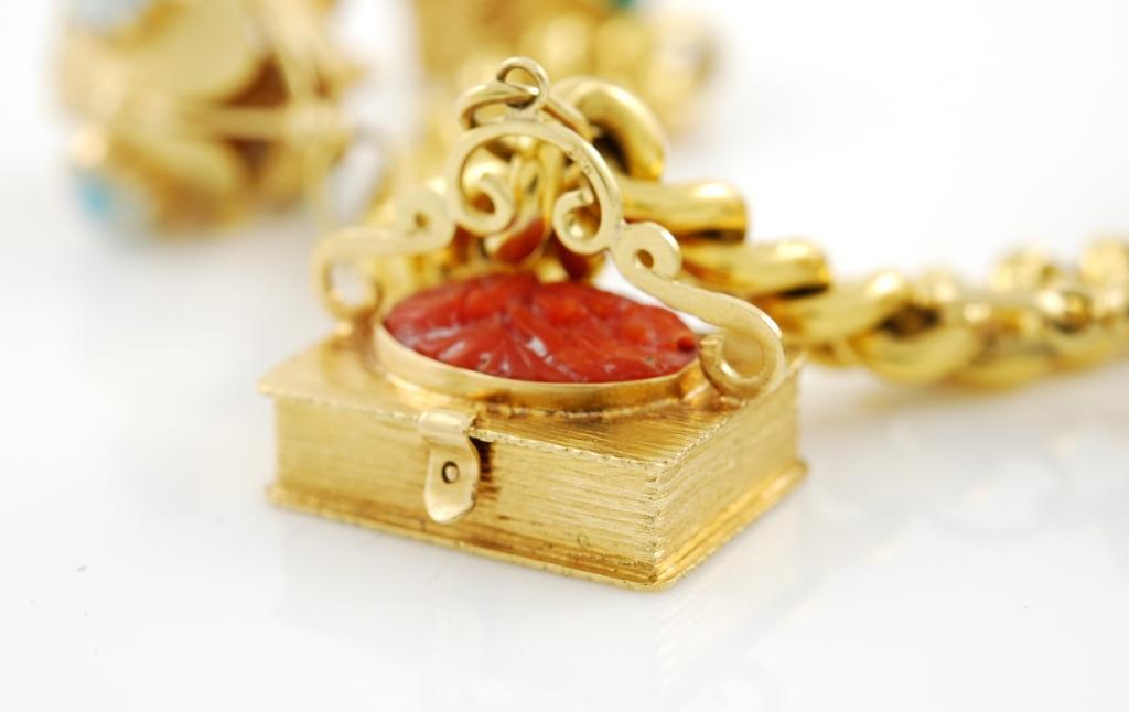 This wonderful venetian bracelet features 7 charms, included a box with coral, a little house, an opening oyster with a pearl inside. The pendants hang from a beautiful gold link bracelet.