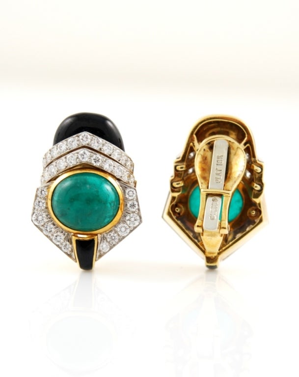 Beautiful pair of David Webb earclips in 18kt yellow gold and platinum, with emerald cabochon, brilliant diamonds surrounding and black enamel. Signed David Webb
