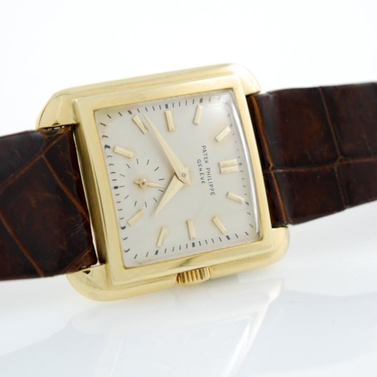 18kt yellow gold square Patek Philippe wristwatch, Ref.2486. 1951 circa. Silver dial with subsidiary seconds at 6, applied gold bar indexes, gold Dauphine hands. Manual winding. Domed crystal. Leather strap with gold buckle.