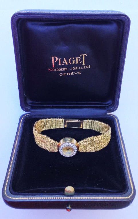 A Piaget 18k yellow gold lady's bracelet watch with diamond-set bezel.  Signed matching reference #3453 features a diamond surround (approx. 1ctw) and integrated woven band. Swiss mechanical movement winds and sets via case back. Complete with