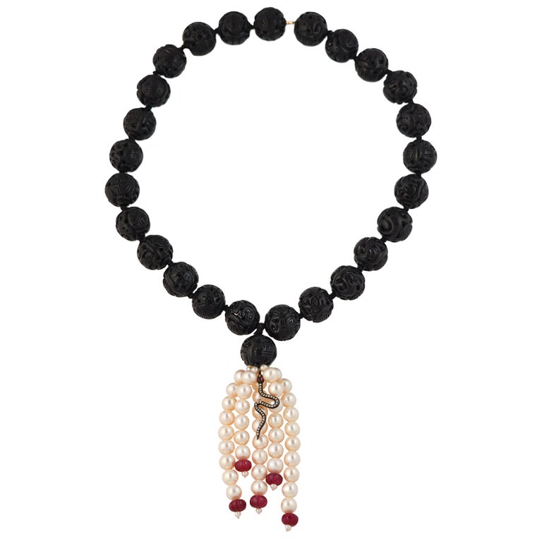 Hand-carved black jet beads with a tassel of pearls, melon rubies with one intricate diamond encrusted snake pendant in the middle.

Overall length: 24