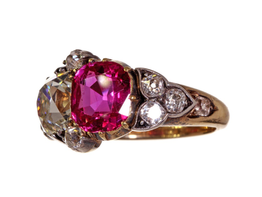 Mid 19th Century Ruby and Diamond Ring. Twin stone ruby and diamond ring with approximate 1.80 carat old mine cut diamond and 1.80 carat untreated Burmese ruby. Open set cutaway collets with old mine cut accent stones.  Silver topped gold. 

Circa