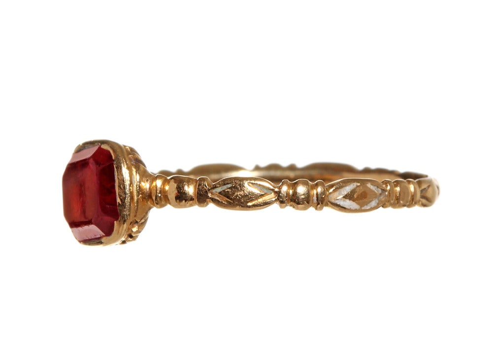 18th Century Georgian era gold garnet ring. A very red garnet is set in a reeded closed back setting in bright 18k gold. English in origin, found in London. Circa 1760/1800

Size 6.5. Easily sized down. Could be sized up with some expense to match