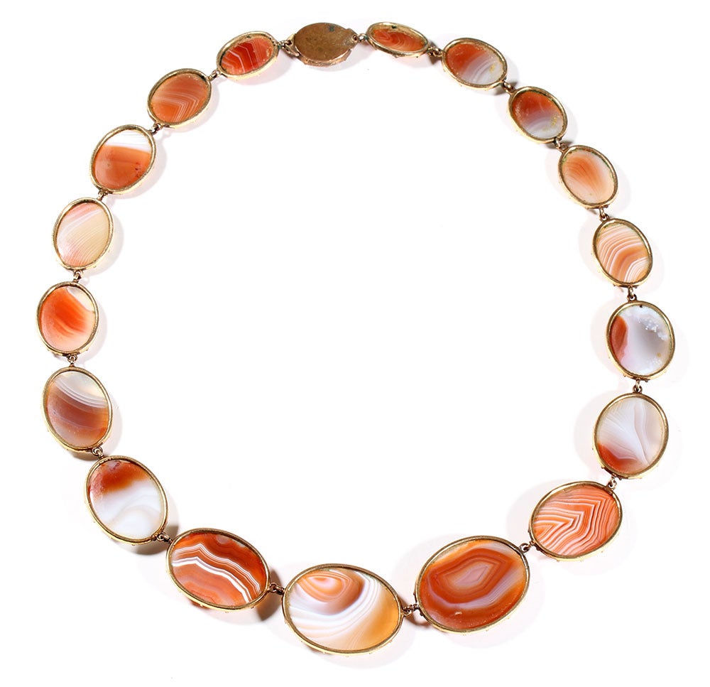 Early 19th Century agate necklace set in gilt metal.  English in origin, this necklace dates to 1800-1830.  The nicely matched and graduated agate stones are set in cut down collet settings.  Each stone is sliced thin allowing light to pass through