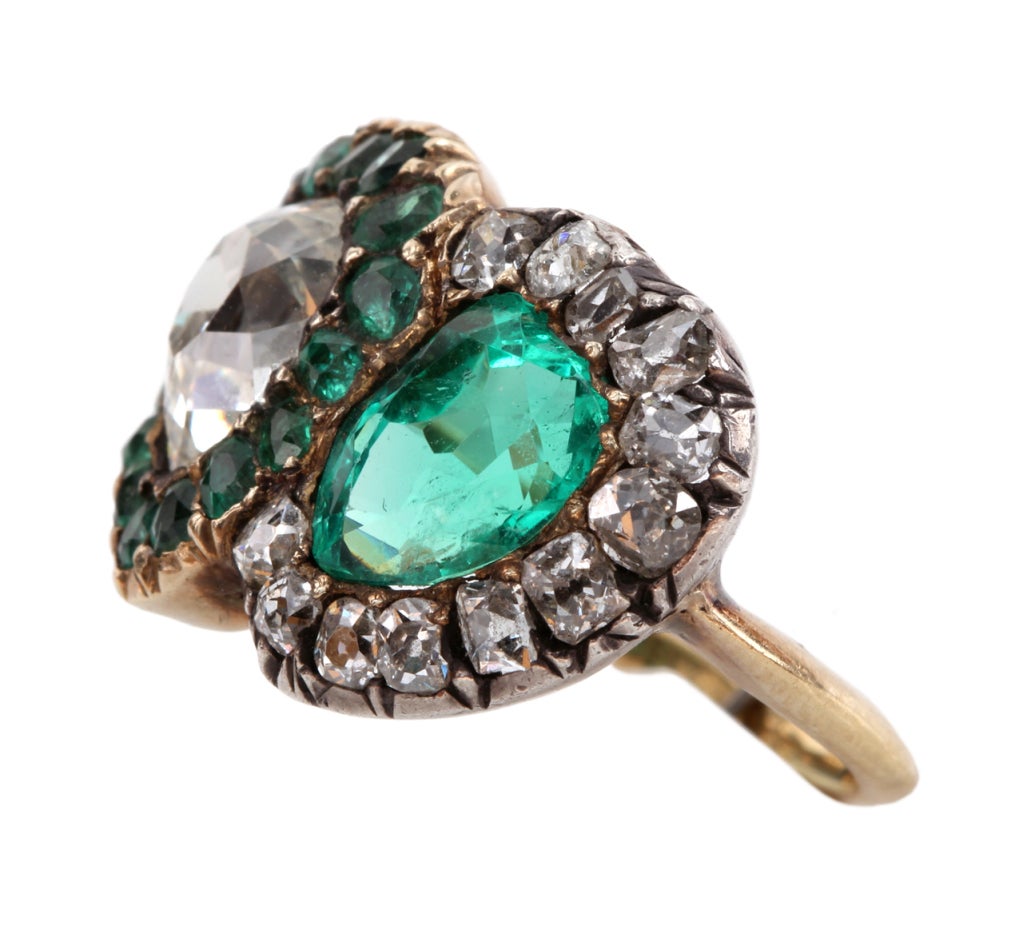 English twin heart ring with beautiful old cut diamonds and emeralds. Approximate 1.30 ct pear shaped diamond and 1.20 ct emerald. Silver and 15k gold. Size 5.5, can be sized.

Please see bellandbird.com for more of our rings.