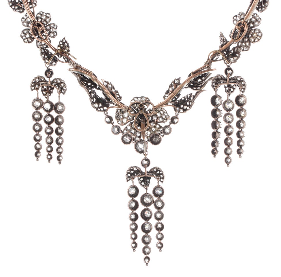 Rare Victorian Garland en Pampille Diamond Necklace and Earrings possibly 
French in the style of Frederic Boucheron.
This piece is done in the naturalist style popular in the time period. All dangling tassels are removable, the two outer convert