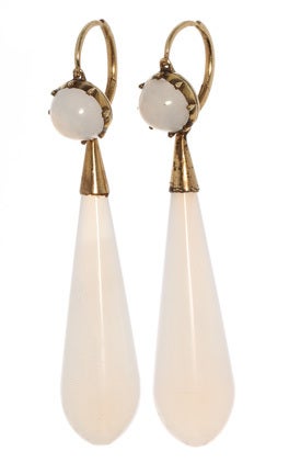 Long torpedo shaped day and night earrings in gilded gold settings. Beautiful white chalcedony. The size and design was dictated by fashion and economic factors of the period. The exaggerated horizontal lines of the dress and hairstyle needed to be