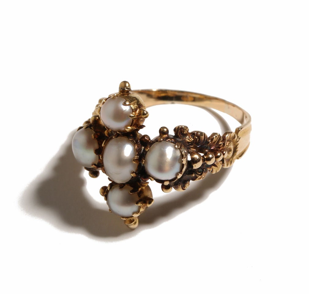 Made in between 1790 and 1820, this beautiful Georgian style setting is done in 18k gold with natural pearls. The pearls are set in a striking maltese cross shape. This antique ring provides a large scale example for a Georgian era ring. Currently a