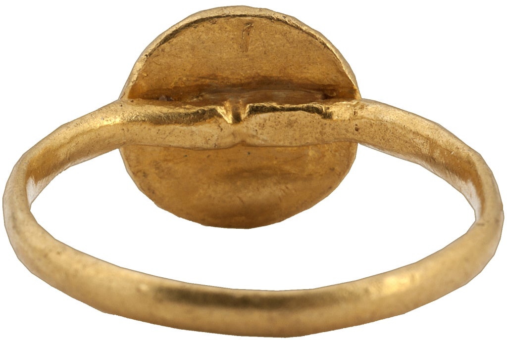 Gold
Circumference 58.5 mm.; weight 4.8 gr.; US size 8 ½; UK size Q ½

Marriage rings of the Byzantine period depict the bride and groom with Christ who performs the marriage rite, in the present case by placing crowns on their heads. Below the