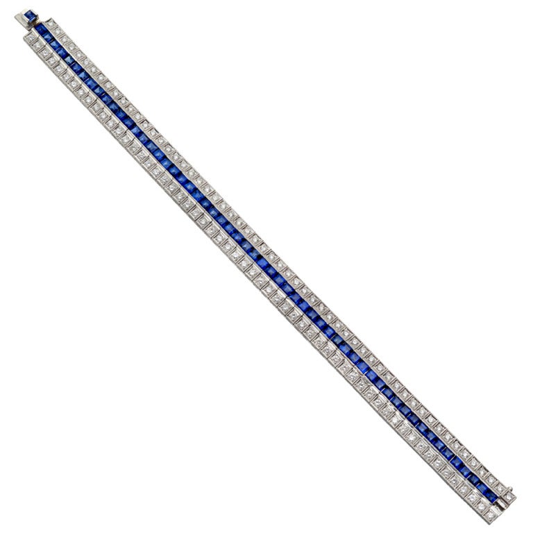 Sapphire and diamond 3-row line bracelet, centering on a channel-set row of square-cut sapphires weighing approximately 11.37 total carats, flanked by a bead-set row of diamonds above and below, the diamonds weighing approximately 2.89 total carats,