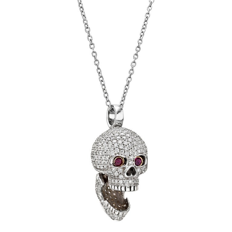 Pavé diamond large skull pendant, with hinged jaw and opening round-cut ruby eyes, mounted in 18k white gold, on an 18k white gold cable chain, designed by Deakin & Francis for Hancocks of London.