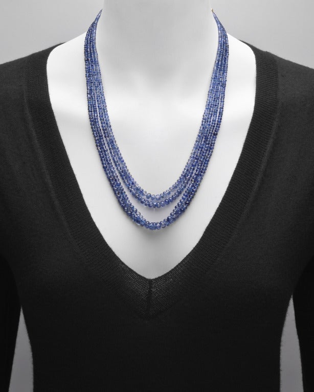 Collana di zaffiri blu chiari a 4 fili, con zaffiri del peso totale di circa 337 carati, chiusura a gancio in oro giallo 18k e catena per regolare la lunghezza, che sospende una nappina di zaffiri con cappuccio in stile foliato. Lunghezza 18
