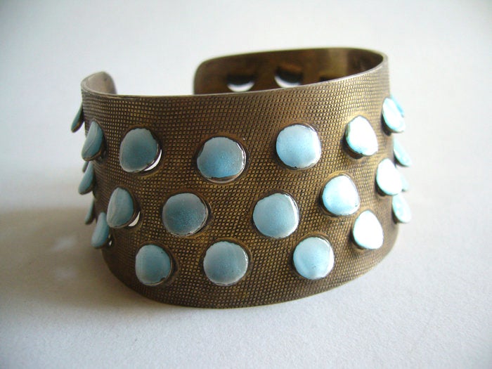 A sterling silver bracelet with punched out enamelled 'scales' created by Norwegian designer, enamelist and jeweler Grete Prytz Kittelsen. Bracelet is made of sterling silver with a gold wash and pearlescent baby blue enamel.  Piece measures 1 1/2