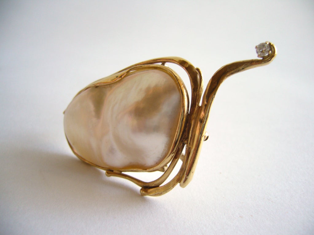 A 14k gold, pearl and diamond pendant/brooch designed by Glenda Arentzen of New York.

Glenda Arentzen has been a studio goldsmith since 1964, exhibiting her work nationally and internationally. She is a former instructor at Fashion Institute of
