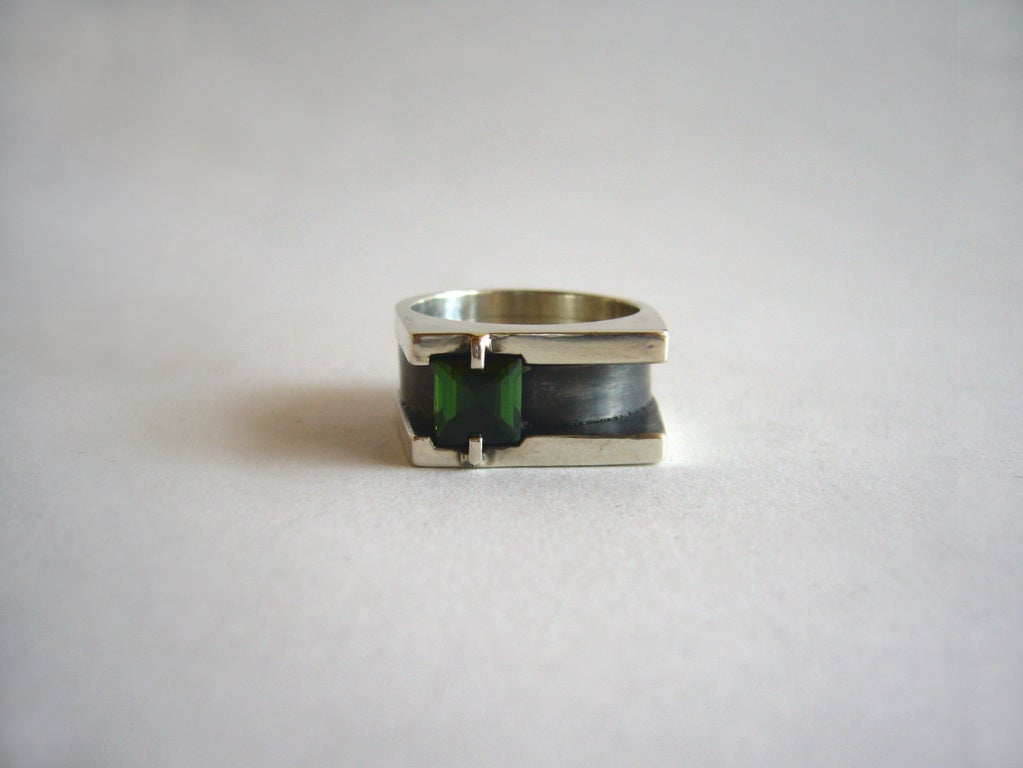 A 1950's modern tourmaline and sterling silver ring designed by Henry Steig of New York.  Ring is suited for either a man or woman.  It features an off center square tourmaline which is prong set within an oxidized shank.  Ring is a size 8.5 and is