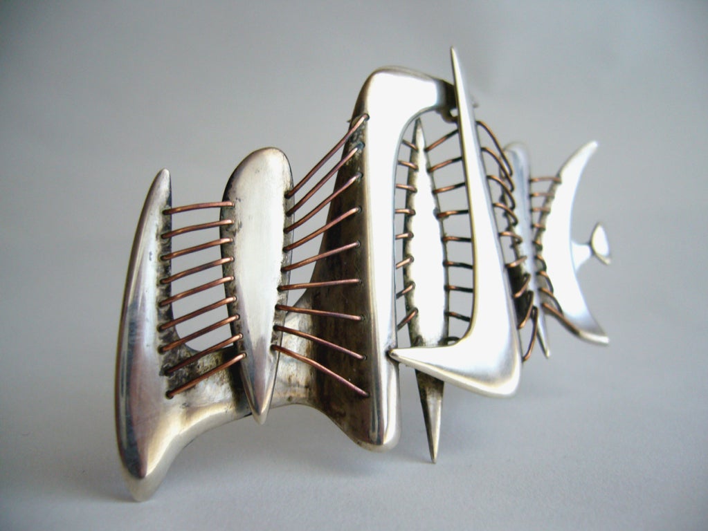 A large, handmade 1950s modern cubist brooch which features intricate lacing of copper wire between its sterling silver boomerang shaped panels.  In the manner of Harry Bertoia.  Piece measures 3.75" x 2.50" and is unsigned. In very good