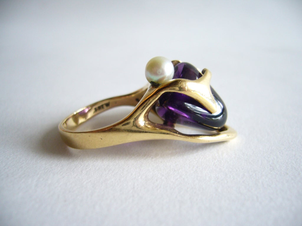 A 14k gold, tumbled amethyst and pearl ring by jeweler J. Arnold Frew of Arcadia, California. Ring is signed Frew and tests positive for 14k gold.  The weight of the ring is 12 grams.

In excellent condition.
