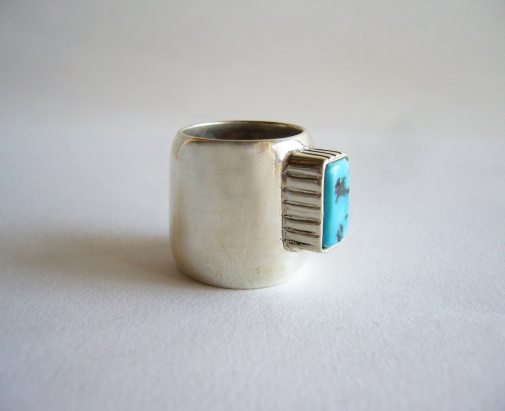 A sterling silver and turquoise cigar band style ring created by Fred Skaggs of Arizona.  Ring measures 3/4