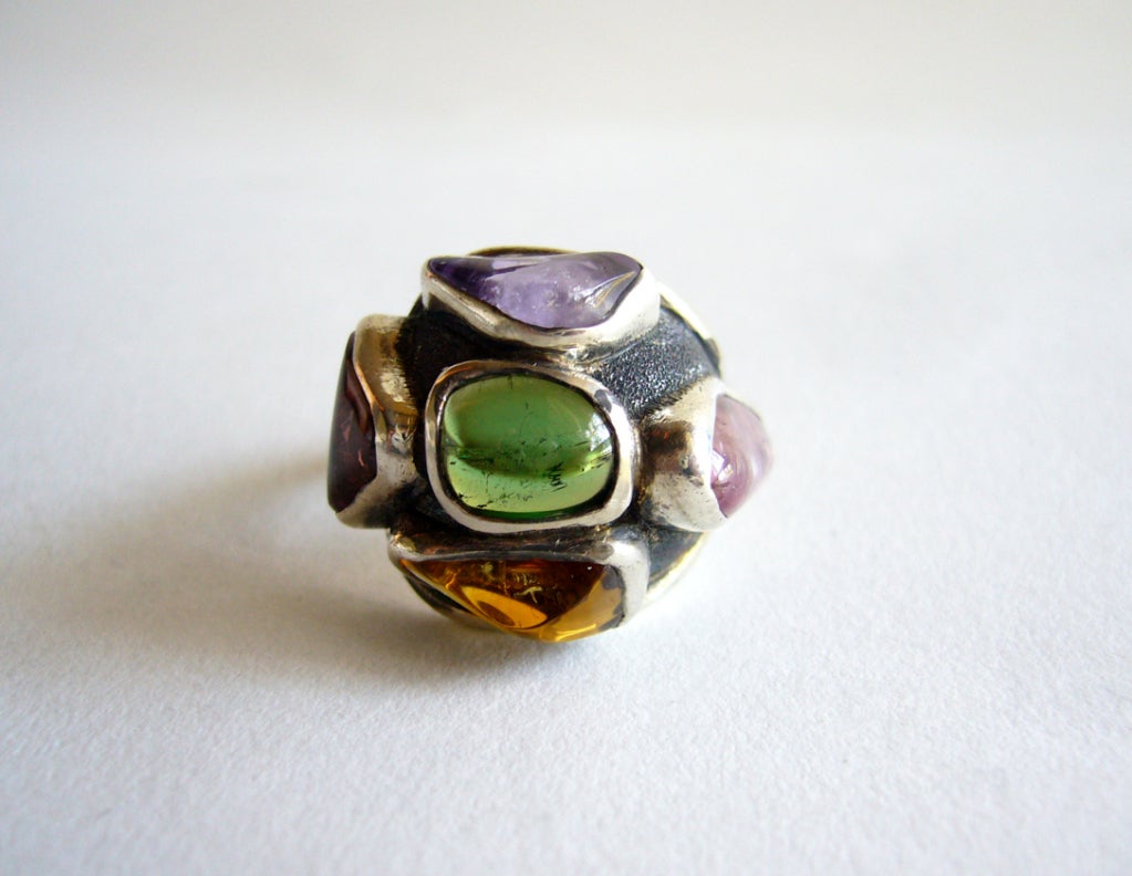 A multicolered gemstone ring created by Fred Skaggs of Scottsdale, Arizona.  Ring has six natural stones of tourmaline, citrine, peridot and amethyst and is a finger size 6 3/4.  Face of the ring stands about 3/8