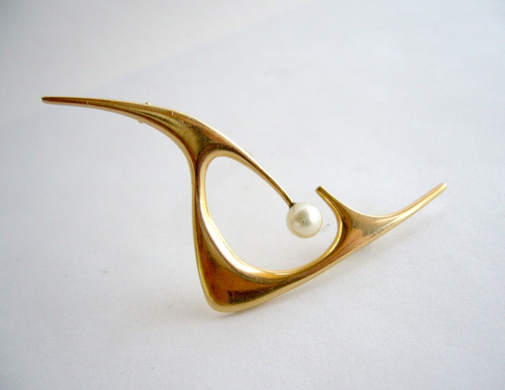 A classic modernist 14k gold and pearl brooch by Ed Wiener of New York circa 1950's.  Measures 3