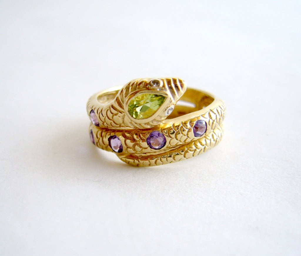 A 14k gold snake ring with five amethysts, a peridot for the forehead and diamond eyes.  Ring is a finger size 6 3/4 and is in excellent vintage condition.