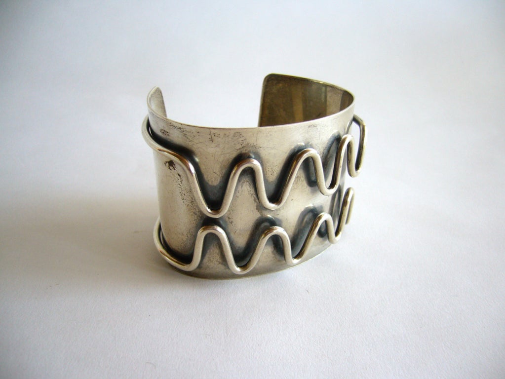 A large sterling silver cuff created by Jules Brenner of New York City, NY.  Brenner also had a studio in Provincetown, Rhode Island as did Ed Wiener and Paul Lobel.  

This massive cuff has incredible detailing of thick, round wire surrounding
