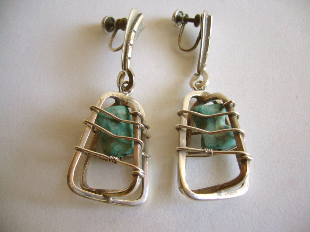 A pair of caged turquoise earrings designed by jeweler Ed Wiener of New York.  Wiener also had a studio in Provincetown, Rhode Island as did Jules Brenner and Paul Lobel. The earrings measure 2 1/4" in length and are signed Ed Wiener, Sterling