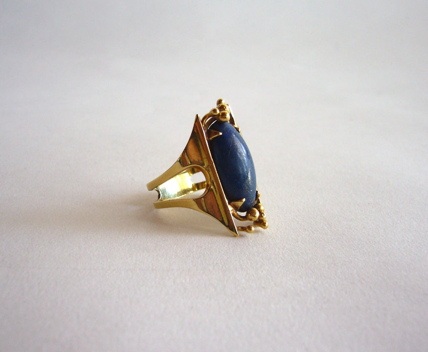 An 18k gold and lapis lazuli ring by Shoshanna of Israel.  Ring is a finger size 8 and weighs 9.4 grams. It comes with its original velvet box which is labeled Jewels by Shoshanna on its interior.  Rings shank is signed 18k. 

In excellent