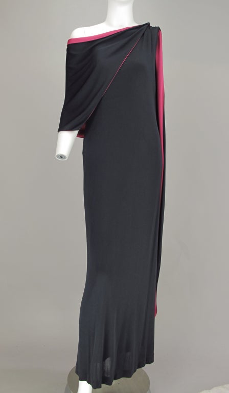 This fabulous dress has more than a touch of old Hollywood glamour and a lot of drama. One shoulder with an attached back drape that is lined in hot pink! Glamourous cut and body hugging fit. One shoulder gown in very dark blue, almost black silk