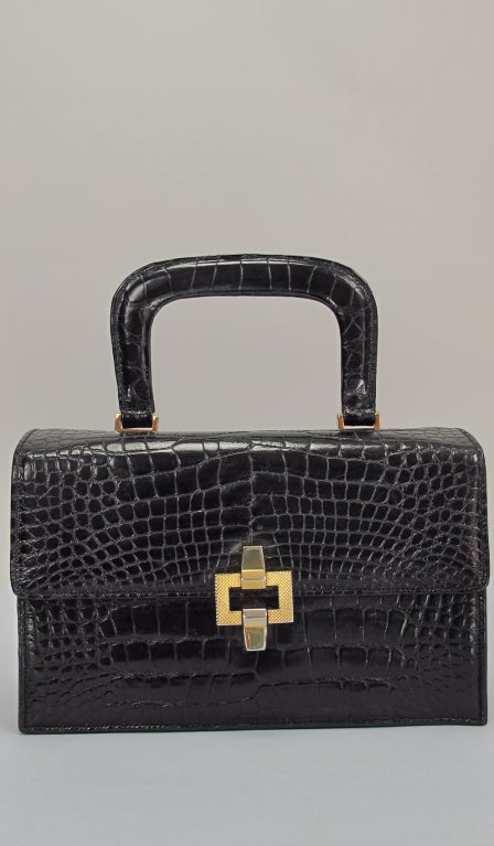 Glazed black alligator box style handbag, gold hardware, fully lined in black leather, with two inside compartments one with a small leather change purse and the other with the original signed mirror.

Measurements are: 
Length 8