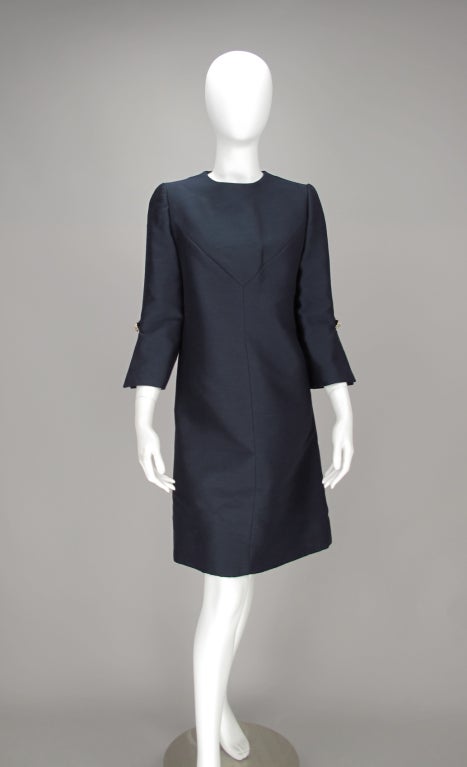 Early 1960s silk & wool dress in navy blue...lovely construction details inverted v front seaming...bracelet length sleeves are slashed to elbow with rhinestone button detail...dress closes with hooks and eyes at neck back and a rhinestone button