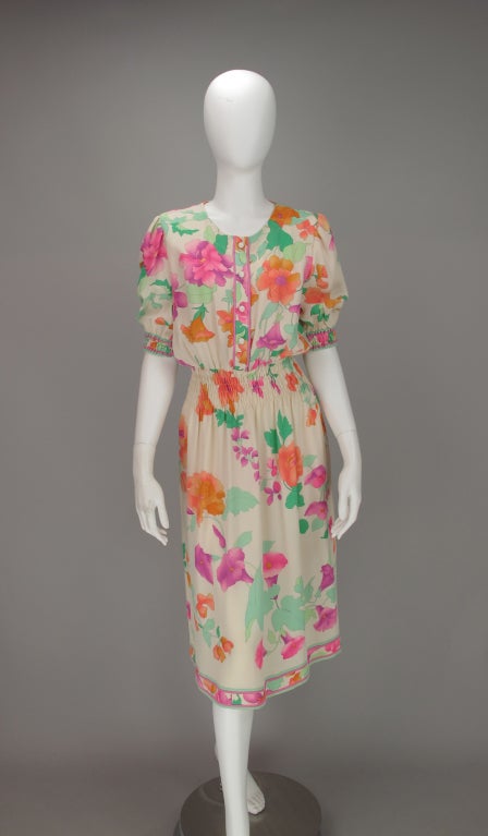 Fabulous floral silk print dress from Leonard, Paris...cream ground with vibrant printed fantasy flowers...fluid silk...pull on style dress with button front bodice...short sleeves with smocked elastic band cuffs...elastic smocked waist, softly