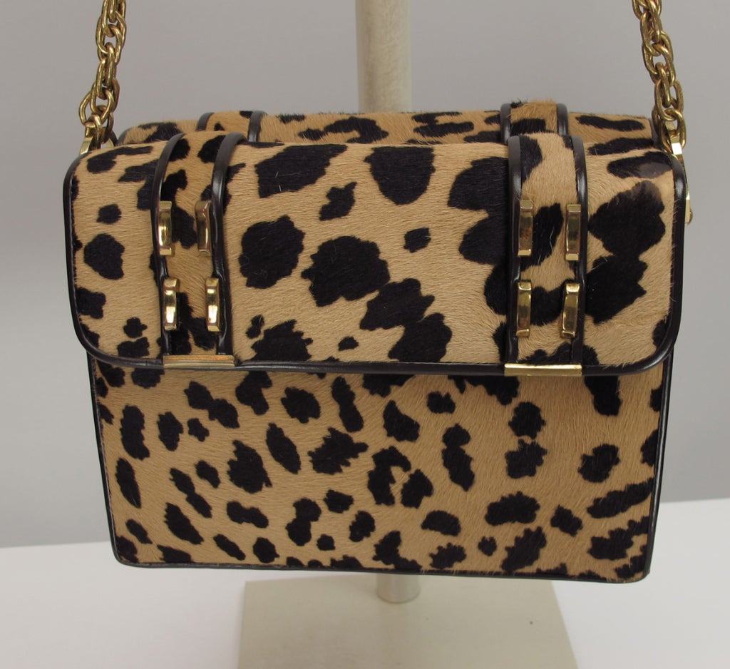 Fun mod style handbag from the 1960s...flap opening on front and back...narrow open center compartment...lined in cream leather...sides of bag and cording are dark chocolate brow leather...brass chain and hardware...inside open pockets with original