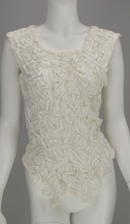 Unique lace top from Comme des garcons...Cream lace with soutache applique…sleeveless top…zipper closure at back hem to waist…short split tails at hem back, longer at front…Measurements are: Bust 34” waist 26” hip open back length 21”