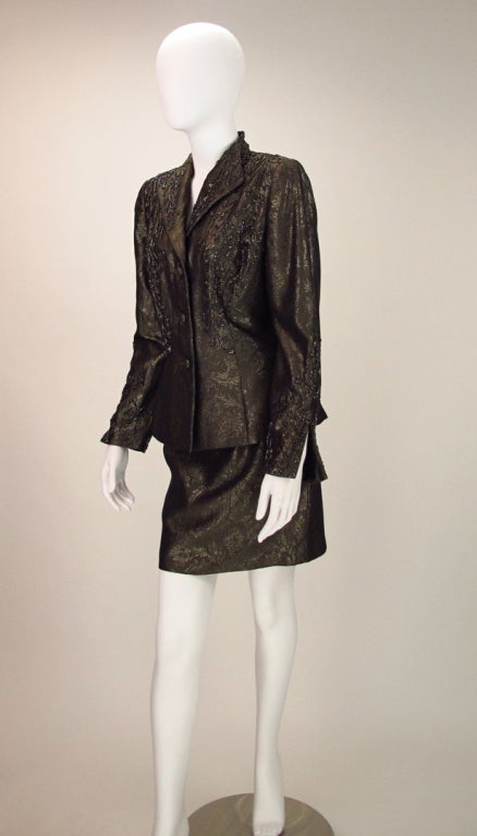 Bronze with a gold sparkle, woven brocade cocktail suit with bronze bead detailing...Three button, long fitted jacket with princess seams...stand away collar with beaded lapels...beaded jacket fronts... Long sleeves have open vent cuffs with lots of