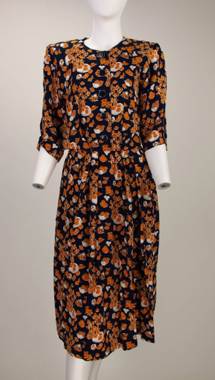 Yves St Laurent modernist print silk dress…Blue figured silk ground with an autumnal print of fruits & leaves, done in gold and white…Button front bodice has elbow length raglan sleeves, each sleeve is pleated at the hem and has a decorative button,