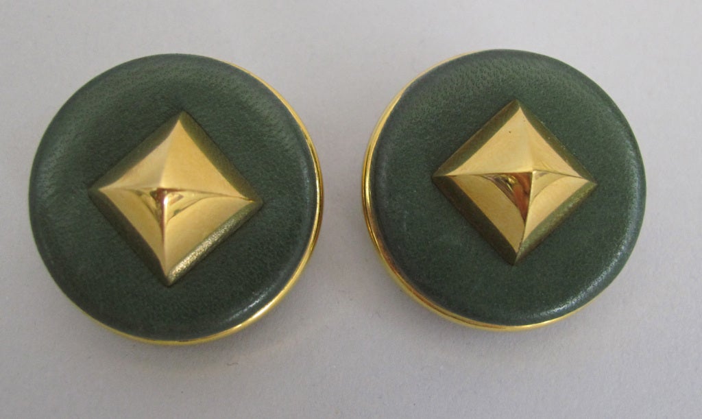 Green leather discs with gold rims are set with large pyramid shaped stud…from the 1990s.