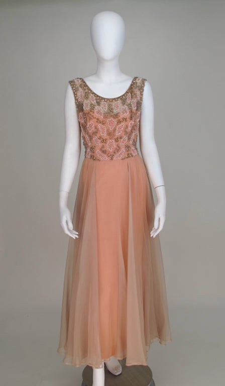 Fairy tail pink, scoop neck beaded bodice silk gown from the 1950s...Gown is lined in pink crepe, under skirt is fitted with a deep center back vent...Dress closes with a painted metal zipper...

All our clothing is dry cleaned and inspected for