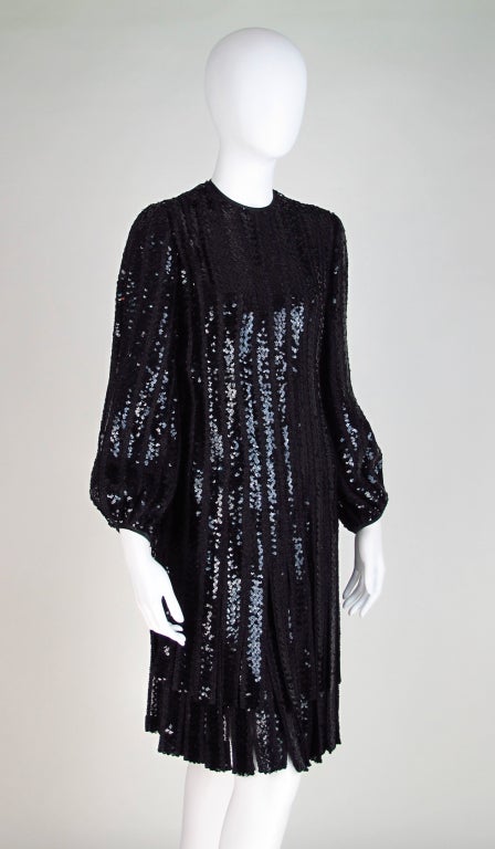 1970s black sequin & lurex fabric with double fringe car wash hem...James Galanos from the 70s...Round neckline, long sleeves that are full at the cuff...Dress is fitted through the body...Skirt has a double tier of sequin encrusted wide