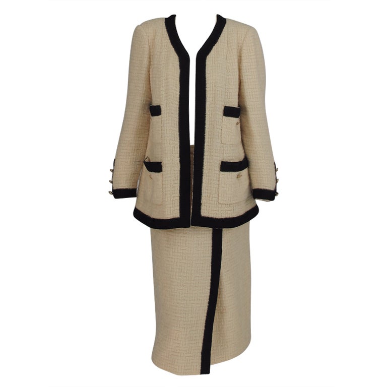 Iconic Chanel suit at 1stDibs  whose creation is the iconic boxy suit in  tweed with braid trims, gold buttons, and silk lining