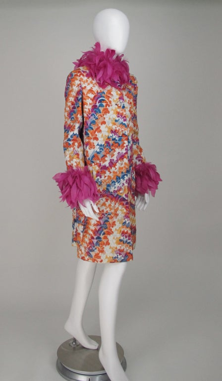 Fabulous Silk brocade evening coat, Miss Dior from early 1970s...In dazzling shades of fuchsia, orange, and bright blue with gold thread...The neck and cuffs are trimmed in fuchsia coq feathers...Fitted coat with hip front flap pockets...deep center