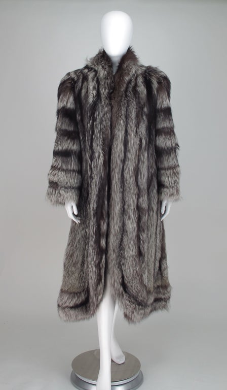 Luxurious silver fox coat from Fabian, furriers Knightsbridge, London 1990s...Silky, luscious pelts with a dramatic combination of silver and black make this coat a stand out...The design features horizontal banding on the sleeves, stand away collar