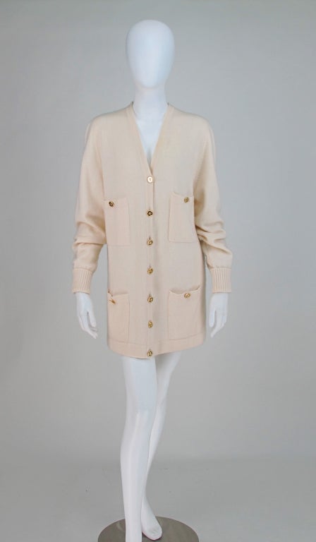 Classic Chanel sweater in gorgeous cream cashmere...Long V front cardigan sweater with gold logo buttons, 4 button through patch pockets, ribbed cuffs...In excellent condition...Fits like a Medium/Large...All our clothing is dry cleaned and