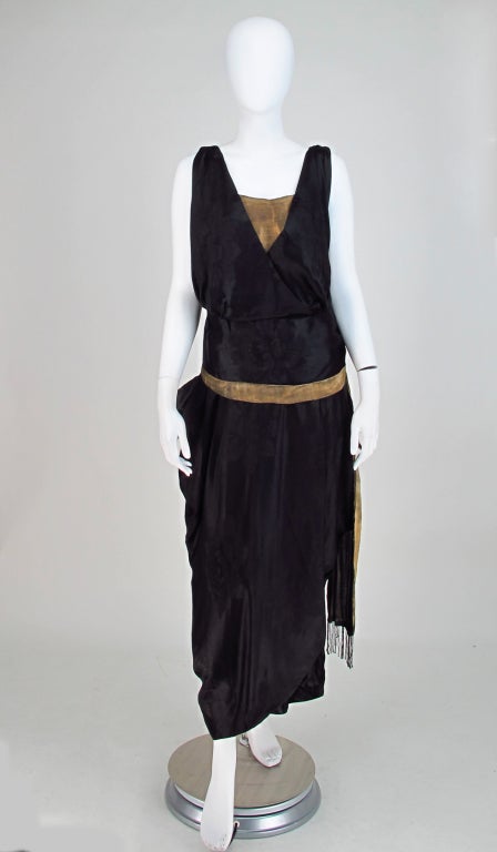 From the late 1900s/early 1920s an Orientalist influenced black silk damask gown with gold lame and beaded trims...Not quite the body con freedom of the 20s, there is a bit of structure in the underpinnings of the bodice, with a loose wrap camisole