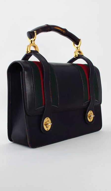 Rare to find Gucci black leather, bamboo handle handbag from the 1960s...Like a chic lunch box, with green & red Gucci trim...In excellent condition...

Measurements are: 
9