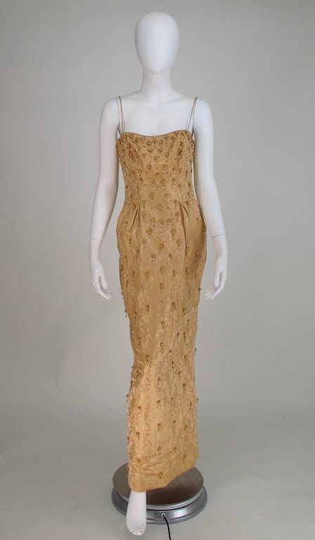 Certainly worthy of Marilyn Monroe, it's hard not to picture her wearing this gown and sashaying down the red carpet in all her loveliness...Ceil Chapman beaded woven gold silk brocade fishtail gown from the 1950s, decorated with rhinestones and