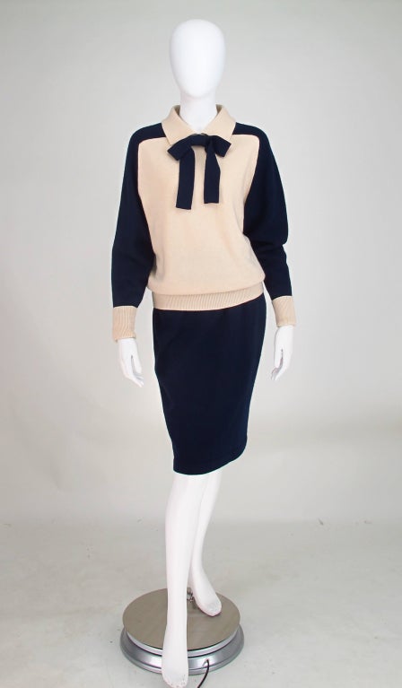 Chanel 2pc cashmere knit set...Pull on raglan sleeve sweater with body of cream and sleeves of navy with coordinating bow in navy and cuffs in cream, pull on navy skirt...Weighty ply cashmere...In excellent wearable condition...

All our clothing