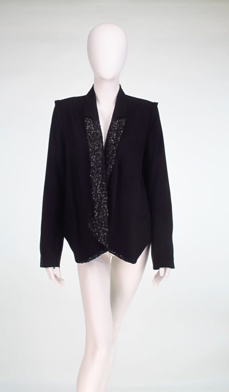 Ann Demeulemeester's take on the classic tux jacket, which brings to mind the teddy boys of 1950s & 60s London...Black wool tux style jacket with capped padded shoulder, short back vent, deep sequined lapels, narrow collar fronts, bound horizontal