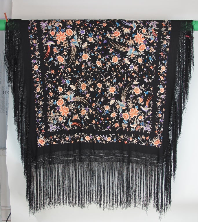 Exotic black silk Canton embroidered shawl from the 1920s...Heavily embroidered with birds and flowers in soft hues of peach and blue...In excellent condition there are a couple of very tiny holes which aren't seen unless pointed